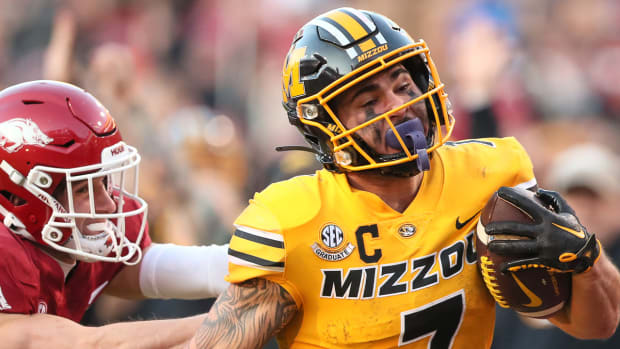 Missouri running back Cody Schrader ripping off a run as Hudson Clark tries to defend